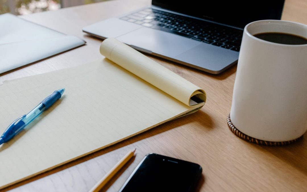 Rustig overzicht maken voor na overlijden regelen, aan een bureau met laptop, notitieblok en telefoon